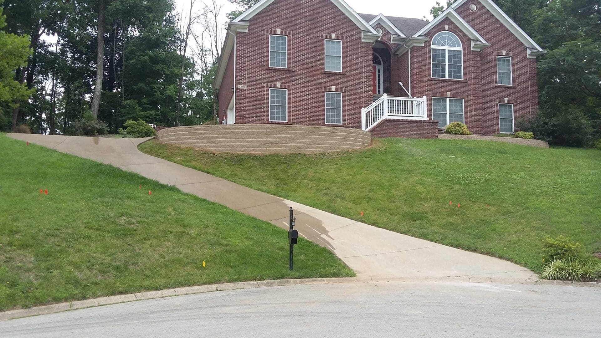 A house with a driveway and steps leading to it.