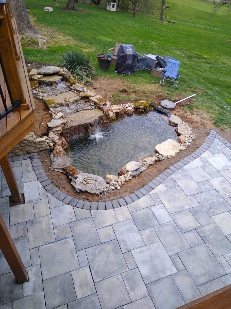 A patio with a pond and water features.